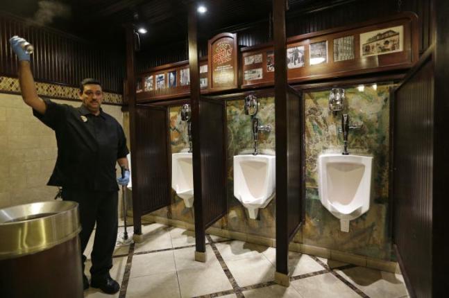 Julio Fernandez sprays air freshener while mopping up a mess in a bathroom at the Main Street Station casino, Las Vegas. The wall holding up the urinals is a piece of the Berlin Wall. The wall that once separated East from West Berlin has largely disappeared from the city. The few sections that remain stand as potent monuments to the ideological divisions of the Cold War. But 25 years after the Berlin Wall fell, some 120 parts of it can now be found in more than 40 countries, from Britain to South Africa and the United States. (AP Photo/John Locher)